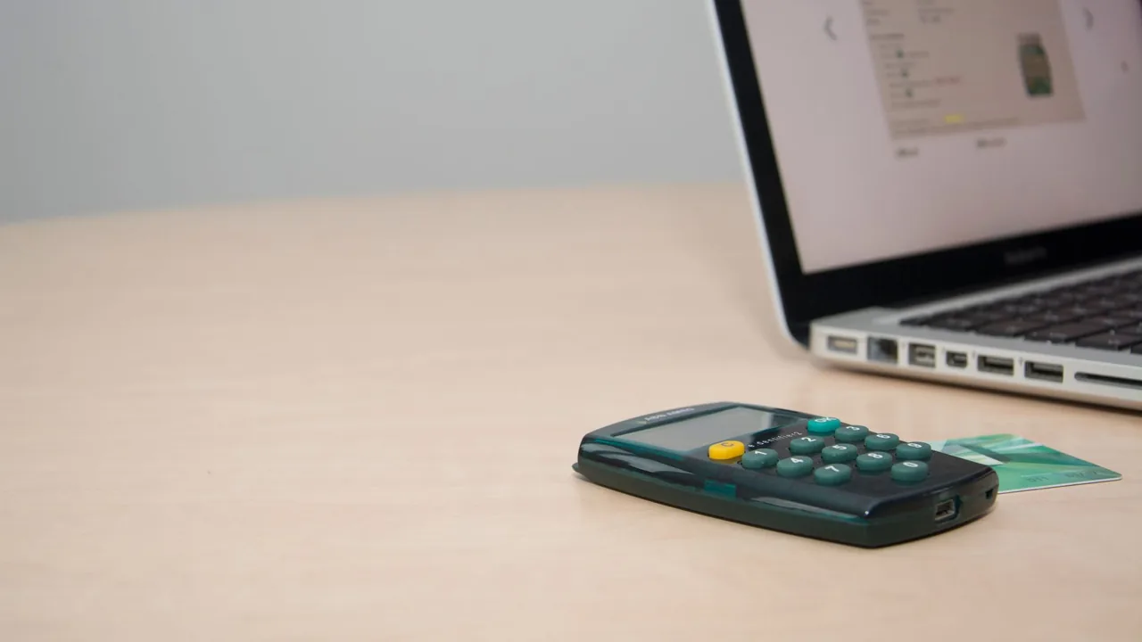 Credit cards, coins, and a notepad on a desk, representing paying down debt