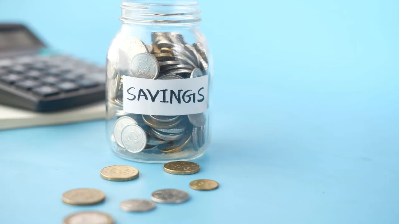 A piggy bank beside stacked coins, representing saving toward a goal